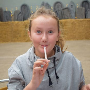 Young girl licking a chocolatey spoon